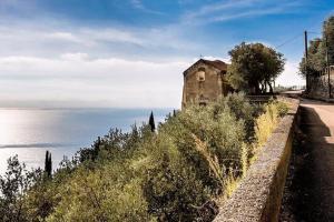 an old building on a hill next to the ocean at La Finestra sul fiordo in Furore