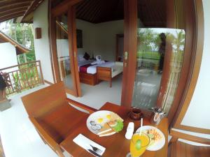 een kamer met een bed en een tafel met eten erop bij Amaya Cottage Ubud by SHM in Ubud