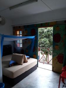 a room with a bed and a sliding glass door at Fatehah Inn in Kuala Tahan