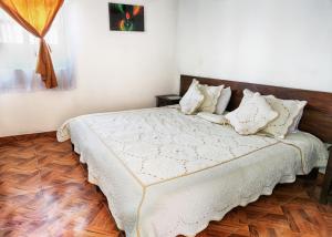 a bedroom with a bed with white sheets and pillows at Esquina Colonial in Villa de Leyva