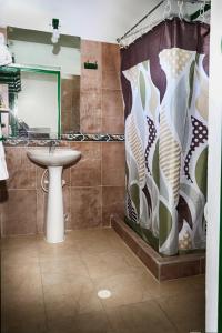 a bathroom with a sink and a shower curtain at Esquina Colonial in Villa de Leyva