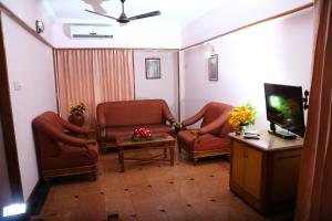 a waiting room with two chairs and a tv at Mayura Residency in Guruvāyūr