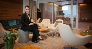 a woman sitting on a chair in a room at Hotel Aateli Hillside in Vuokatti