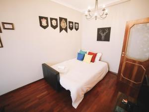 1 dormitorio con 1 cama con sábanas blancas y almohadas coloridas en OPORTO GUEST Harry Potter flat with Parking, en Oporto