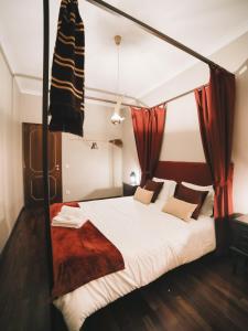 1 dormitorio con cama con dosel y cortinas rojas en OPORTO GUEST Harry Potter flat with Parking, en Oporto
