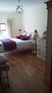 a bedroom with a large bed and a dresser at Hazel Cottage in Limerick