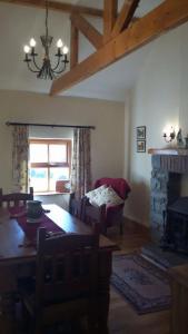 sala de estar con mesa de comedor y chimenea en Hazel Cottage en Limerick