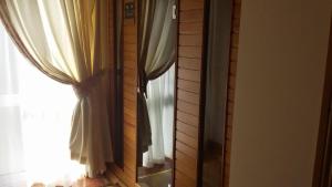 a mirror in front of a window with curtains at Hazel Cottage in Limerick