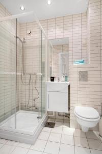 a bathroom with a shower and a toilet and a sink at Frogner I, As Home in Oslo