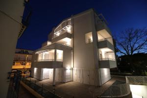 een groot gebouw met 's nachts verlichting bij Residenza Riva Azzurra in Rimini