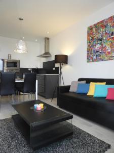 a living room with a black couch and a table at L'Appart Thermal in Vittel