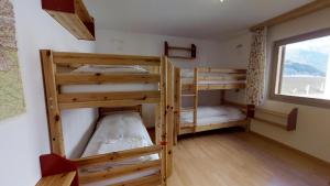 due letti a castello in una stanza con finestra di Pavrella a Celerina