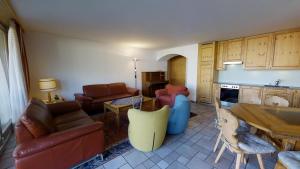 un soggiorno con mobili, tavolo e cucina di Pavrella a Celerina Altre 16 foto