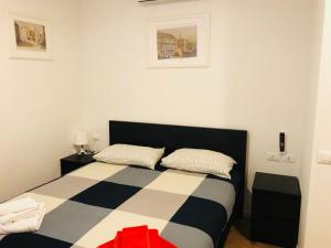 um quarto com uma cama preta e branca com 2 almofadas em Appartamento Le Cupole em Pádua