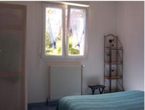 1 dormitorio con cama y ventana en Gîte Le Clos des Pins, en Colleville-sur-Mer