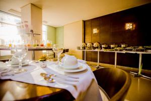 a table with white plates and utensils on it at Hotel San Pietro in Pato Branco
