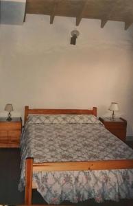 1 dormitorio con 1 cama de madera y 2 mesitas de noche en Juana Pinamar en Ostende
