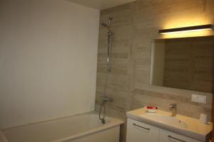 a bathroom with a sink and a bath tub and a mirror at Old Town Niguliste Residence in Tallinn +26 photos