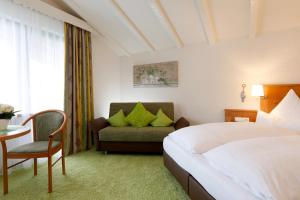 um quarto de hotel com uma cama e um sofá em Gästehaus Gaiser em Baiersbronn