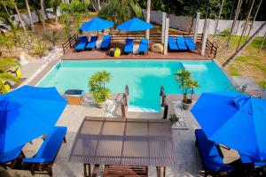 an overhead view of a swimming pool with blue chairs and umbrellas at Morning Star in Mirissa
