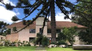 a house with a tree in front of it at Parador Hampel in São Francisco de Paula