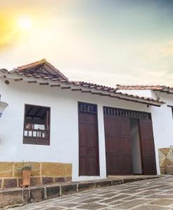 una casa blanca con dos puertas marrones en Casa de Huéspedes Samuel, en Barichara
