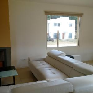 Piedra Amarilla في بونتا دل إستي: غرفة معيشة مع أريكة بيضاء ونافذة