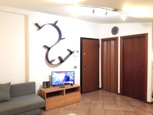 ミラノにあるStudio Flat-Palestrina 34のリビングルーム(ソファ、壁掛けテレビ付)