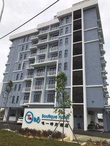 a large building with a sign in front of it at The One Boutique Hotel in Sekinchan