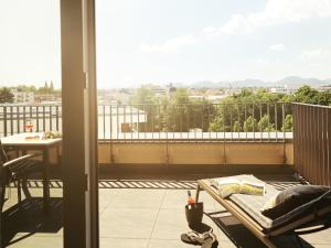 balcón con mesa y vistas a la ciudad en Maximilians Boutique-Hotel Landau en Landau in der Pfalz