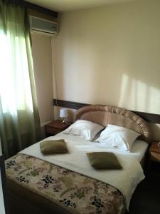 a bedroom with a large bed with white sheets and pillows at Motel Neno in Bijeljina