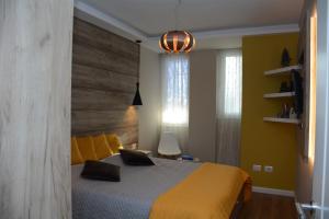 a bedroom with a yellow bed with a wooden headboard at Central Luxury Apartment in Tirana