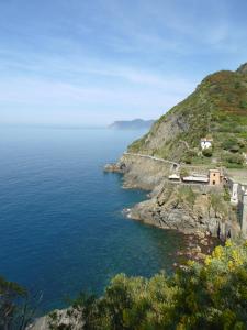 a house on a cliff next to the ocean at Camping La Sfinge in Deiva Marina