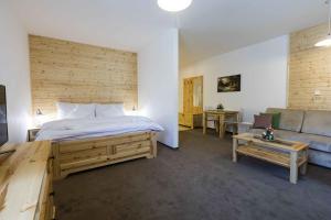a bedroom with a large bed and a couch at Rezort Gothal Apartmány a Penzióny in Donovaly +88 photos