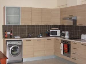a kitchen with a washing machine and a microwave at Mazotos Panoramic Village in Mazotos