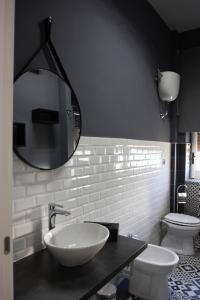 łazienka z umywalką, toaletą i lustrem w obiekcie Pompei Palace B&B w mieście Pompeje +37 zdjęć
