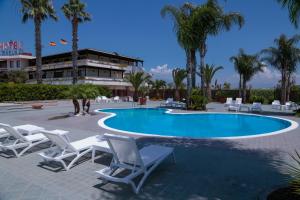 a swimming pool with lounge chairs and a resort at Perla Hotel e Garden - Free Parking and Pool - Open area with Beautiful view of the Landscape in Capaccio-Paestum
