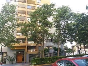 un edificio de apartamentos con árboles delante de él en Edificio Villaseca, en Santiago