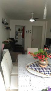 a living room with a table with a bowl of flowers on it at Hospedagem da Grega in Balneário Camboriú