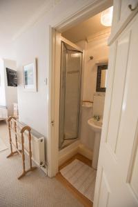 a bathroom with a walk in shower next to a toilet at Court Barton Farm in Aveton Gifford