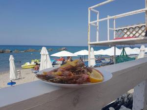 a plate of food sitting on a ledge next to the beach at B&B Rometta Beach in Rometta Marea