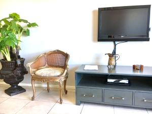 a living room with a chair and a tv at Hightide Apartment in Amanzimtoti