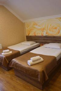 três camas num quarto com toalhas em Guesthouse Gera em Mestia