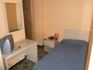 una piccola camera con letto e specchio di Hotel Belvedere a Sanremo