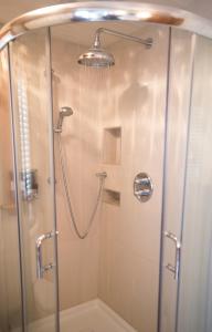 a shower with a glass door and a shower head at Yamachiche P.Q. in Yamachiche