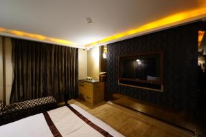 een hotelkamer met een bed en een flatscreen-tv bij 荷村 Motel in Wuqi