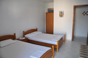 a room with two beds and a mirror at Apartments Stavroula Ηospitality in Nea Vrasna