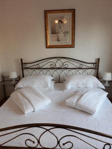 een bed met witte kussens en een foto aan de muur bij Apartments Franka in Samobor