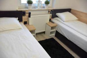 two beds in a small room with a window at Apartamenty Platan Opieszyn in Września