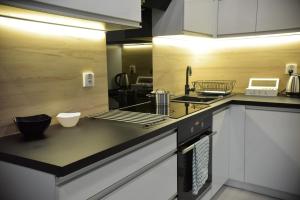 a kitchen with white cabinets and a stove top oven at Apartamenty Platan Opieszyn in Września